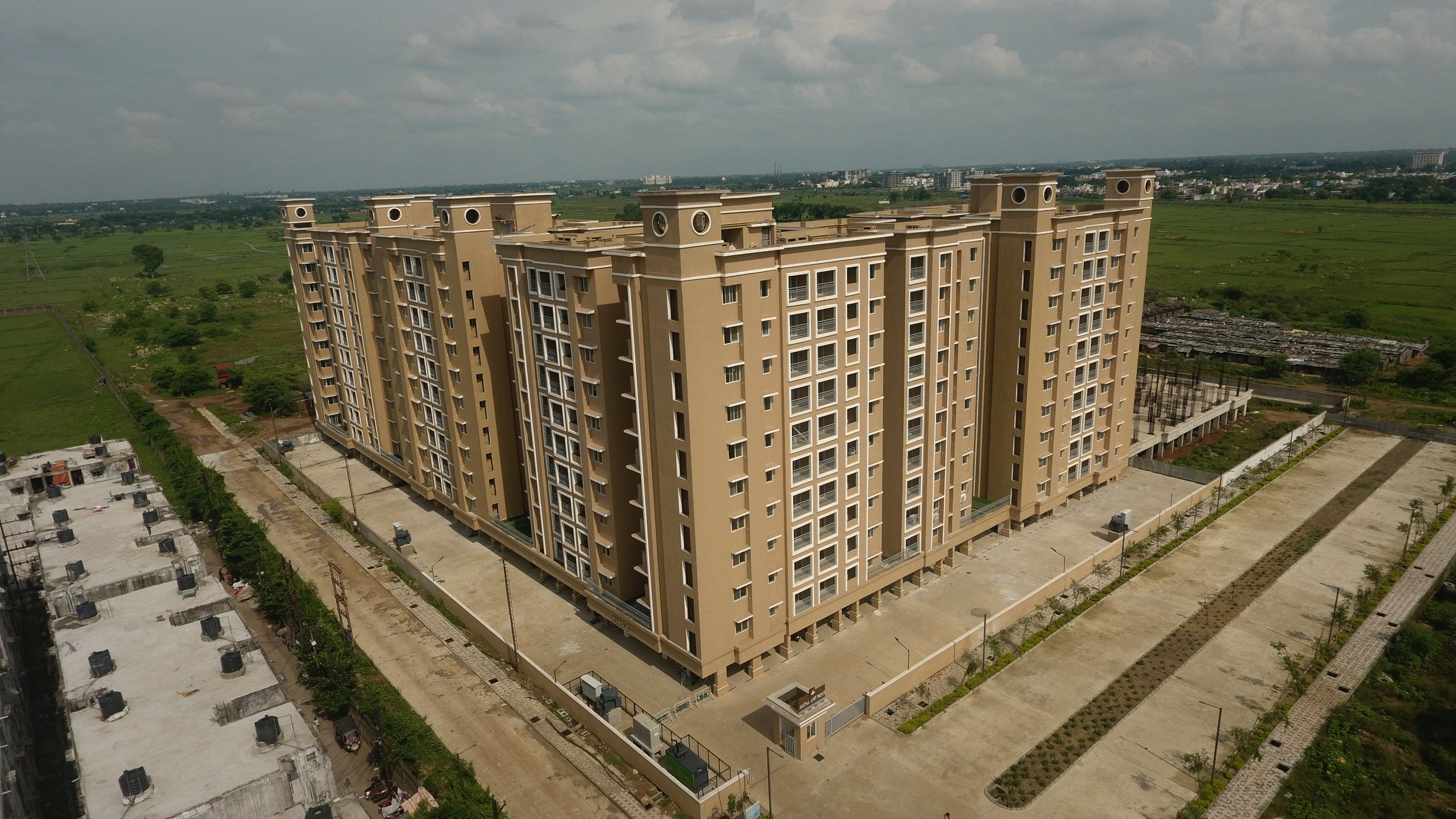Aastha Apartments — aerial view of the sand-gold towers at Anandam World City