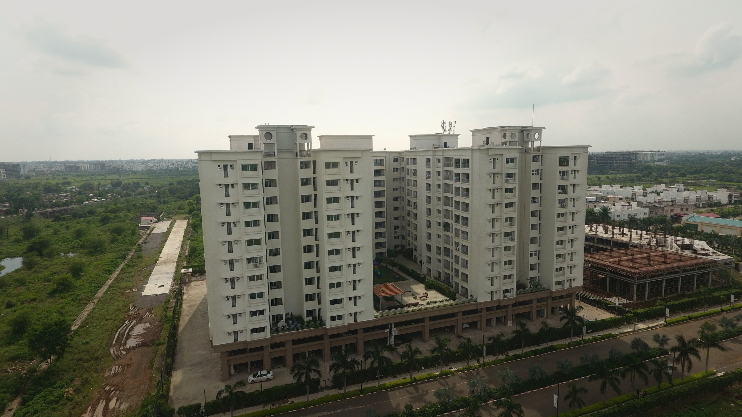 Miraya Apartments — white towers over the landscaped podium at Anandam World City